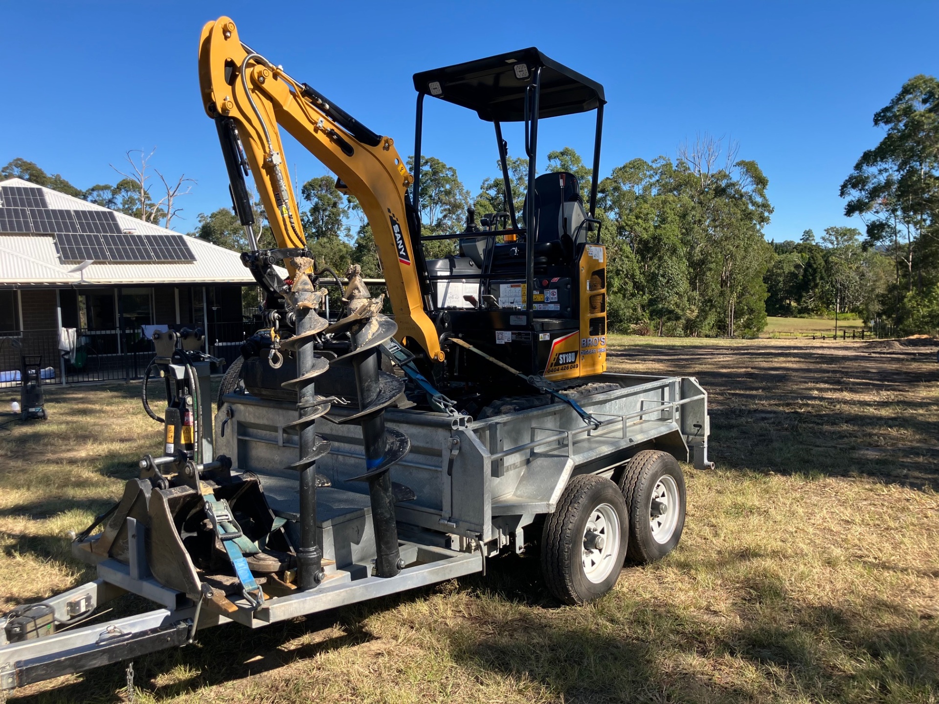 Mini excavator on trailer with auger attachments ready for wet or dry hire